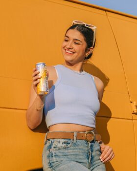 Influencer poses with Pretty Tasty Tea can