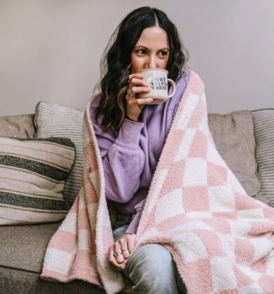 Influencer sitting on a couch and sipping on a mug of Brodo bone broth