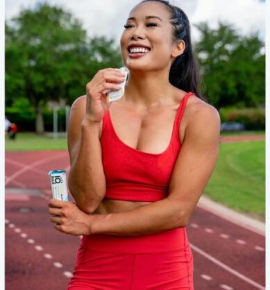 Influencer poses while taking a bite out of IQBAR and smiling