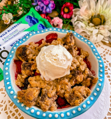 Influencer post of IQBAR Wild Blueberry crumbled over a bowl of berries and topped with vanilla ice cream