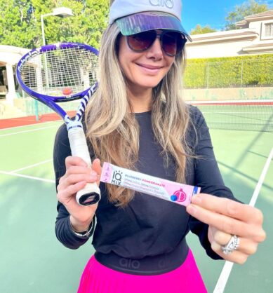 Influencer poses with tennis racket and IQMIX Blueberry Pomegranate