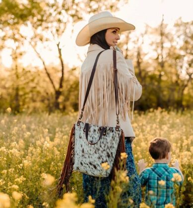 Influencer poses with Jill's Homestead Dolly Double Fringe bag with cow print