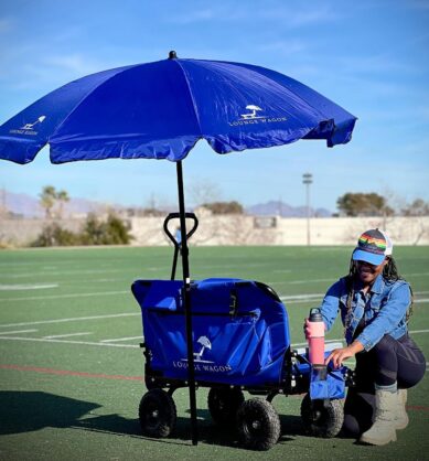 Mom influencer shows off the water bottle holder feature of the Lounge Wagon at a kids soccer game