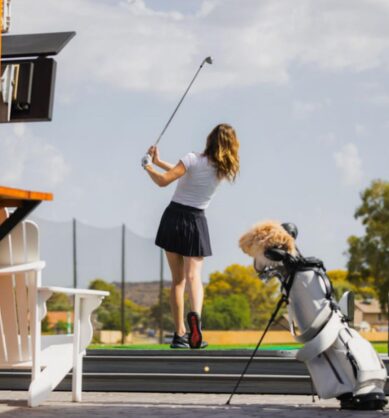 Influencer hits a golf ball on a driving range, Vessel Golf bag in the forefront