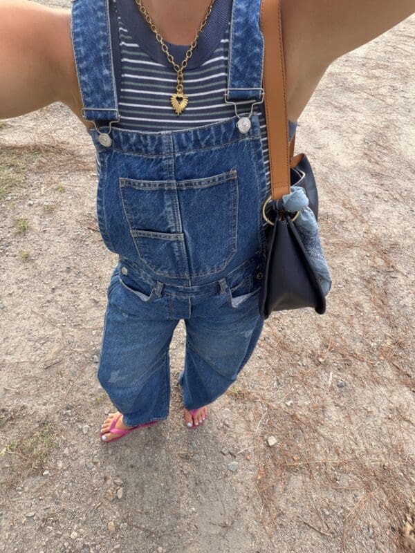 girl in overalls with purse