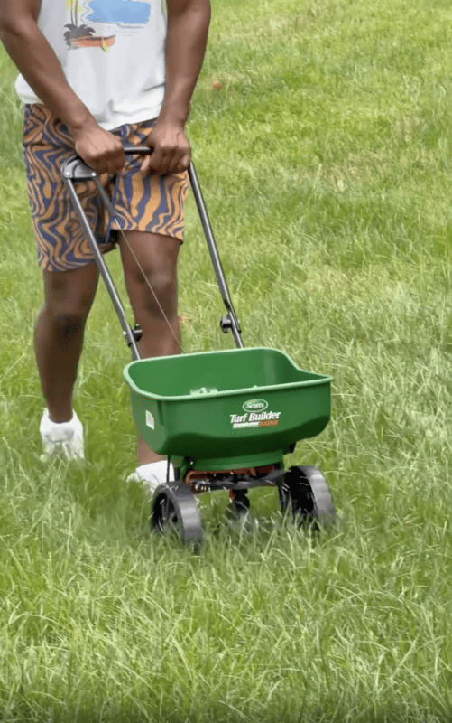 Pushing spreader in yard