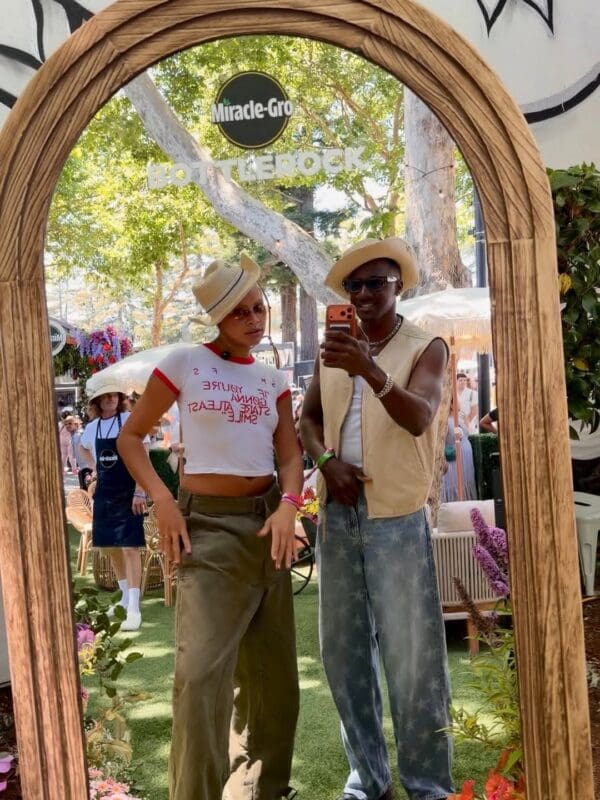 2 people standing in mirror outside