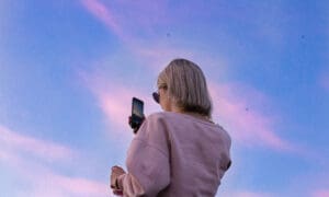 woman taking photo of sunset