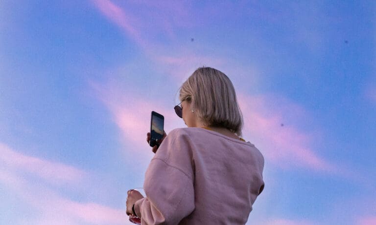 woman taking photo of sunset